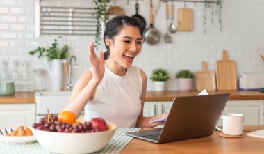 Bilgisayarı kullanan genç Asyalı iş kadını görüntülü konuşma konferansı için konuşuyor. ev kavramından çalışma.