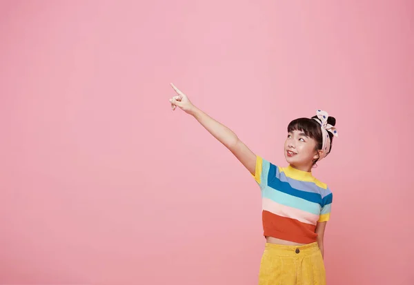 Sorridente Menina Asiática Apontando Dedo Espaço Branco Lado Rosa Isolado — Fotografia de Stock