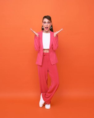 Turuncu arka planda şaşırmış genç bir kadın.. 