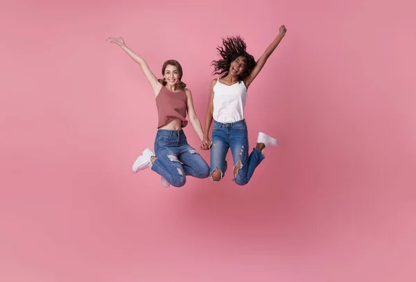 二つの幸せな屈託のない若い女性が空中でジャンプします — ストック写真