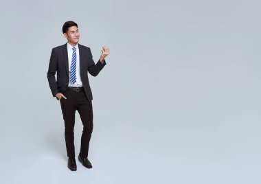 Yakışıklı ve dost canlısı Asyalı iş adamı resmi takım elbise ve el ele tutuşarak gülümsüyor. Beyaz arka plan stüdyo çekimlerinde yer açmak için bir şey sundu..