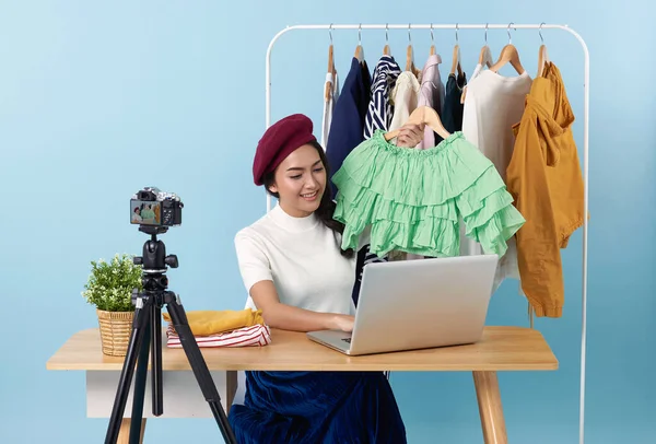Asian young woman live streaming showing clothes in front of camera for sale fashion clothing is blogger presenting for social people.Her is influencer in social online.