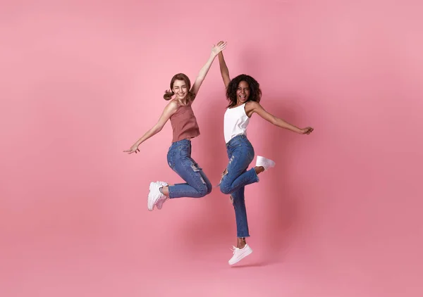 Dos Mujeres Jóvenes Felices Despreocupadas Saltando Sobre Fondo Rosa — Foto de Stock