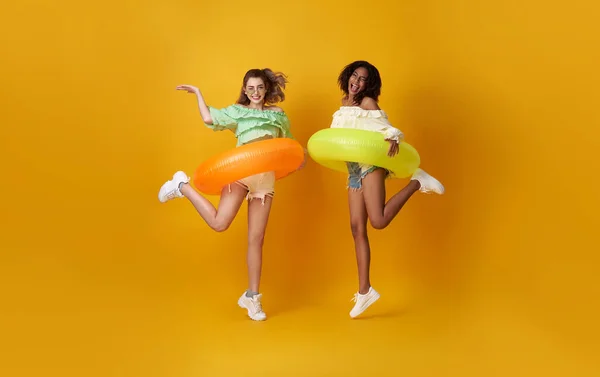 陽気友人女性ドレスで夏服ジャンプとともにゴムリング上のコピースペース黄色の背景 — ストック写真