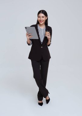 Happy and friendly face asian businesswoman entrepreneur smile in formal suit her using tablet on white background studio shot.