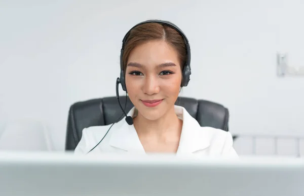 Asian woman Call center agent with headset working on support hotline in modern office.