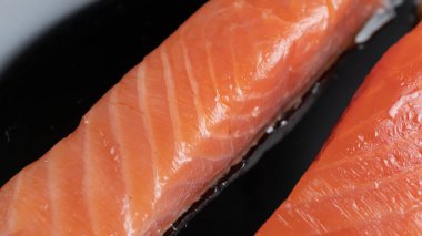Siyah tabakta tuzlanmış somon filetosu parçaları, yakın plan.