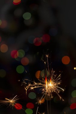 Renkli ışıkların arka planında yanan kıvılcımlar