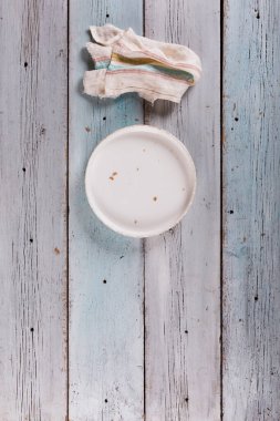 Boş beyaz tabak ve peçeteyi kopyalama alanı olan mavi ahşap masaya koy