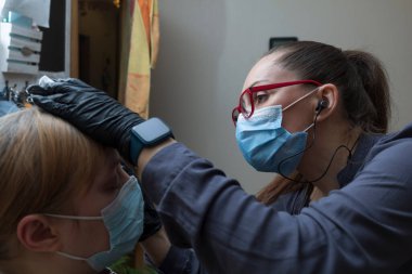 Usta, salgın sırasında müşterinin kaşlarını boyar. İnsanlar koruyucu maskelerle iletişim kurar.