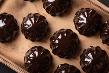 Noel şekerlemeleri çikolatada yakın plan, ahşap tepside, en üstte.