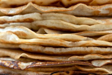 Close-up plan of thin pancakes for Shrovetide with honey and cranberries