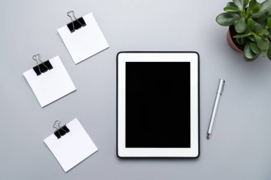 Zaman yönetimi kavramı, görevleri tamamlama, yemek tarifleri. Sayısal tablet ve gri arkaplanda boş kağıt parçaları