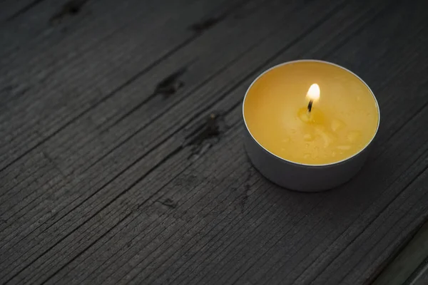木制背景上的黄色燃点蜡烛 带有复制空间 — 图库照片