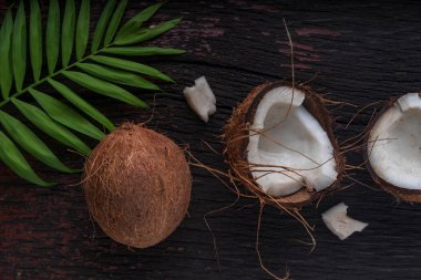 Ahşap arka planda doğranmış hindistan cevizi, üst manzara. Hindistan cevizi sütü ve hindistan cevizi taneleri tropik gıdalardır.