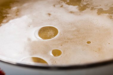 Et suyu ya da vejetaryen çorbasının yüzeyindeki bir damla bitkisel yağın yakın çekimi.