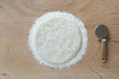 Tahta arka planda pizza hamuru, üst manzara.