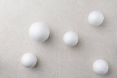 Beyaz beton üzerine köpük topların soyut bileşimi. Noel ve Yeni Yıl Dekoratif Kar Topları