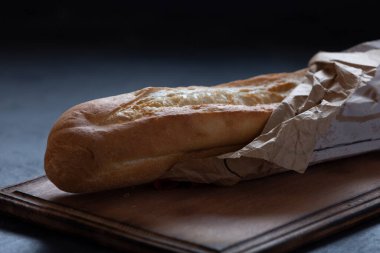 Siyah mutfak masasının üzerinde beyaz un ekmeği, yemek fotoğrafı.