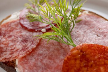 Kurutulmuş sosisli sandviç, kahverengi ekmek, tereyağı.