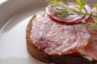 Kurutulmuş sosisli sandviç, kahverengi ekmek, tereyağı.