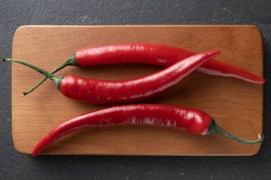 Ahşap mutfak tahtasına biber dökülmüş, yakın plan.