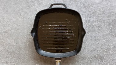 Izgara tavalı pankart ve kızarmış etten arta kalan yağlar. Kirli kızartma tavası