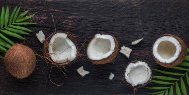 Ahşap arka planda doğranmış hindistan cevizi, üst manzara. Hindistan cevizi sütü ve hindistan cevizi taneleri tropik gıdalardır.