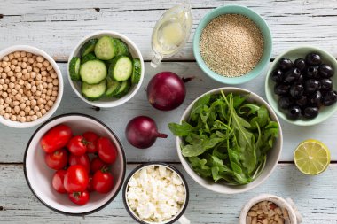Çeşitli kaselerde vejetaryen yiyecekler, taze sebzeler, nohut, zeytinyağı