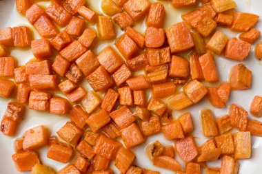 Havuçlar zeytinyağında tavada kızartılıyor, makro shot.