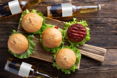 Şişe bira ve lezzetli hamburgerler sulu et köfteleri, fast food, açık hava yemekleri.