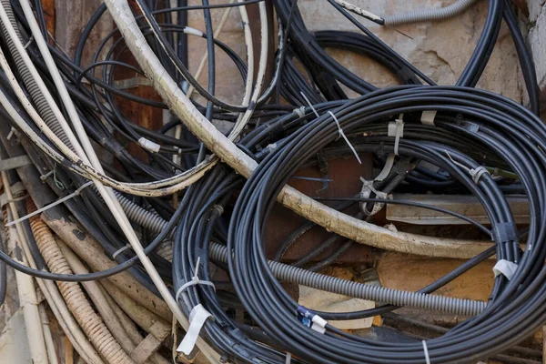 Modern bir şehirde bir binaya elektrik sağlayan elektrik kablosu yığını.