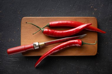 Hot Chili pepper pods on a cutting board, close-up. Hot peppers