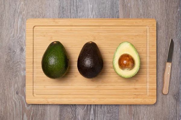 Three Ripe Haas Avocados Kitchen Cutting Board Top View Diet — Stockfoto