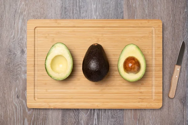 Three Ripe Haas Avocados Kitchen Cutting Board Top View Diet — Stockfoto