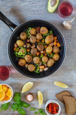 Ev yapımı yemekler, sebzeler, otlar, tavada kızarmış biftek ve yeni patateslerle dolu bir yemek masası.