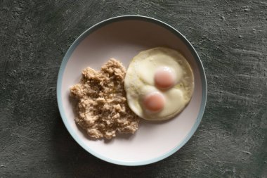 Sağlıklı kahvaltı yulaf ezmesi ve büyük bir tabakta kızarmış yumurta, üst manzara, sağlıklı beslenme.