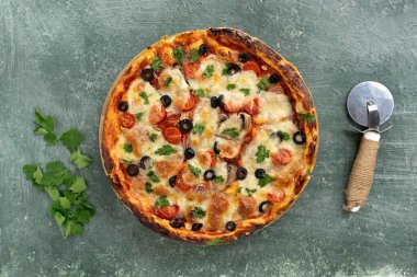 Peynirli, kirazlı, domatesli, zeytinli, otlu, soslu nefis ev yapımı pizza. Üst görünüm, metin için kopyalanma alanı.