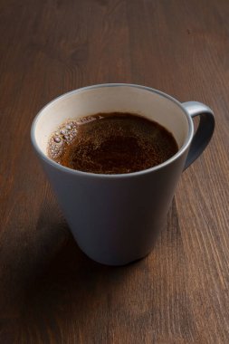 Lezzetli taze doğal kahveyi ahşap masaya kapayın.