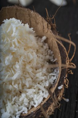 Ahşap arka planda doğranmış hindistan cevizi, üst manzara. Hindistan cevizi sütü ve hindistan cevizi taneleri tropik gıdalardır.