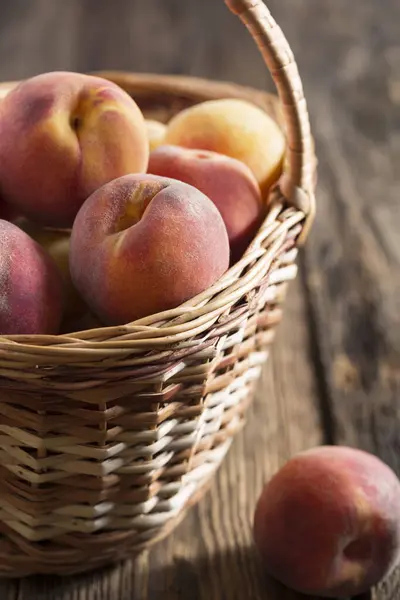 木のテーブルの上のバスケットで桃を熟す クローズアップ 素朴なスタイル — ストック写真