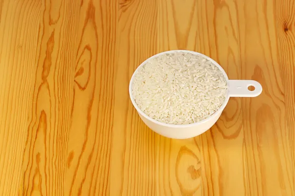 Measuring cup with a rice — Stock Photo, Image