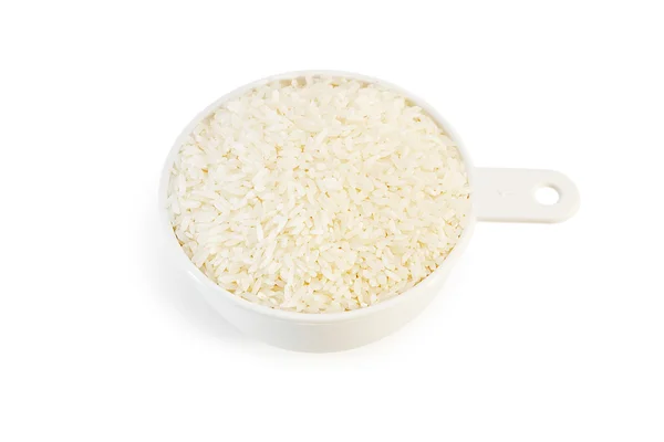 Measuring cup of rice on white — Stock Photo, Image