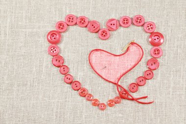 Heart in shape of red buttons and darning needle clipart