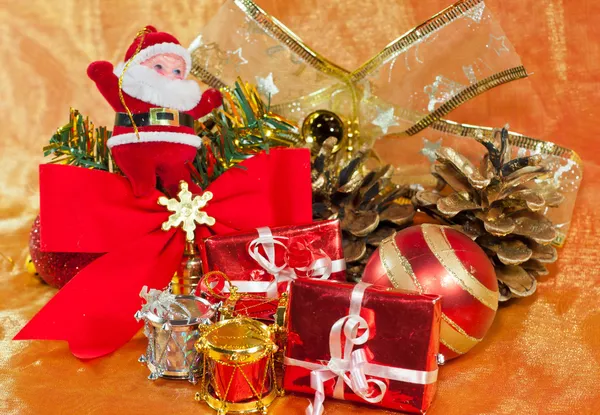 Christmas presents and ornaments on orange — Stock Photo, Image