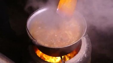 Gulaş baharat ve etle hazırlandı. Sıcak bir yemekten çıkan buhar. Kazanda bir mutfak var. Mutfak spatulasıyla karıştır. Kamp ateşi yemeği..