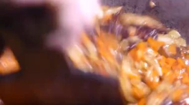 Gulaş baharat ve etle hazırlandı. Sıcak bir yemekten çıkan buhar. Kazanda bir mutfak var. Mutfak spatulasıyla karıştır. Kamp ateşi yemeği..