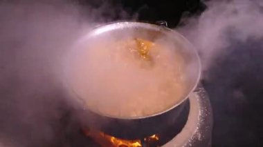 Gulaş baharat ve etle hazırlandı. Sıcak bir yemekten çıkan buhar. Kazanda bir mutfak var. Mutfak spatulasıyla karıştır. Kamp ateşi yemeği..