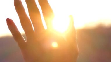Gün batımında güneş ışınları kızın avucunun içinde parlıyor.. 