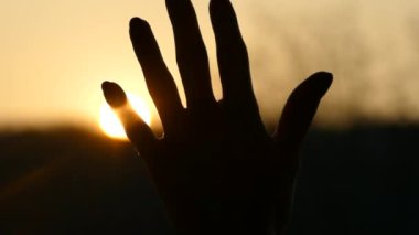 Gün batımında güneş ışınları kızın avucunun içinde parlıyor.. 